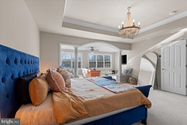 bedroom featuring decorative columns, crown molding, carpet flooring, and a raised ceiling