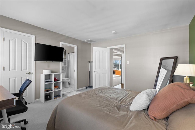 carpeted bedroom featuring ensuite bath