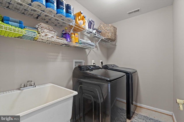 laundry area featuring sink, tile patterned flooring, and washer and clothes dryer