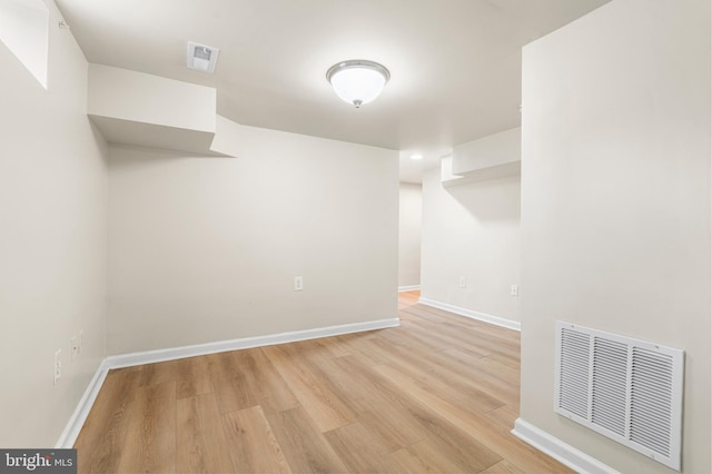 unfurnished room featuring visible vents, light wood-style flooring, and baseboards