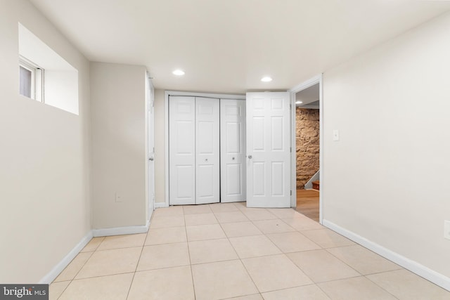 unfurnished bedroom featuring light tile patterned floors, baseboards, a closet, and recessed lighting