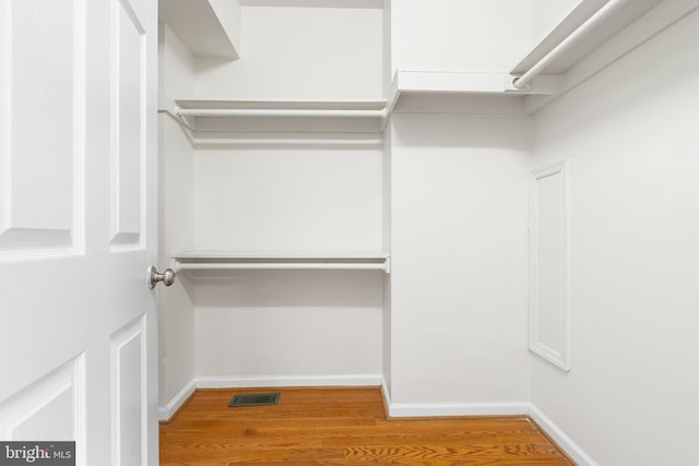 spacious closet featuring visible vents and wood finished floors