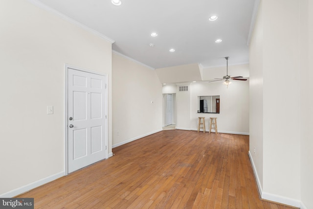 unfurnished living room featuring ornamental molding, recessed lighting, light wood-style flooring, and baseboards