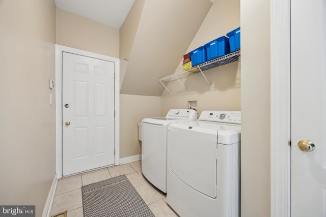 laundry area with light tile patterned floors and washer and clothes dryer