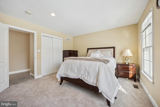 carpeted bedroom featuring multiple windows and a closet