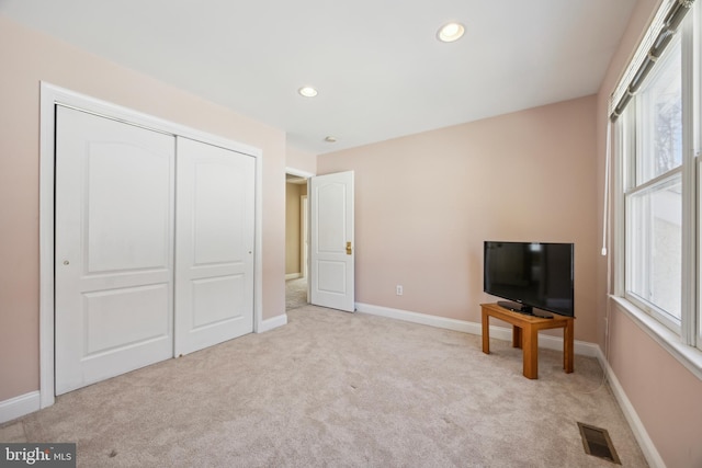 interior space featuring light carpet and a closet