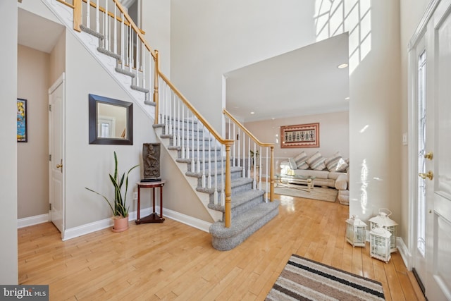 entrance foyer with wood-type flooring and a towering ceiling