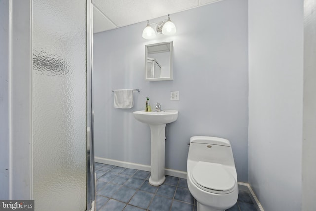 bathroom with tile patterned flooring, sink, toilet, and walk in shower