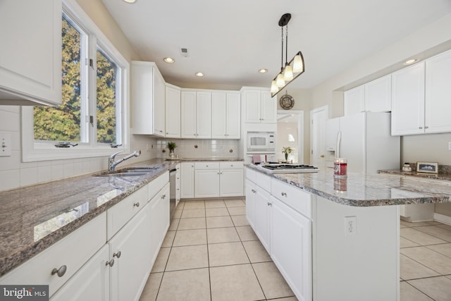 kitchen featuring white cabinetry, sink, appliances with stainless steel finishes, and a kitchen island