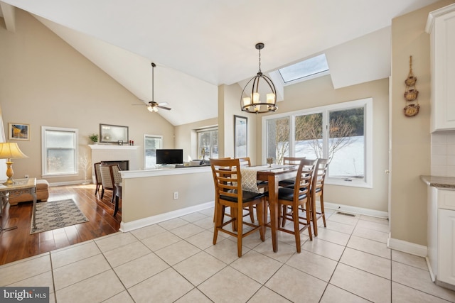 dining space featuring lofted ceiling, a healthy amount of sunlight, and light tile patterned flooring