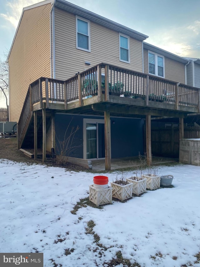 snow covered house with a wooden deck