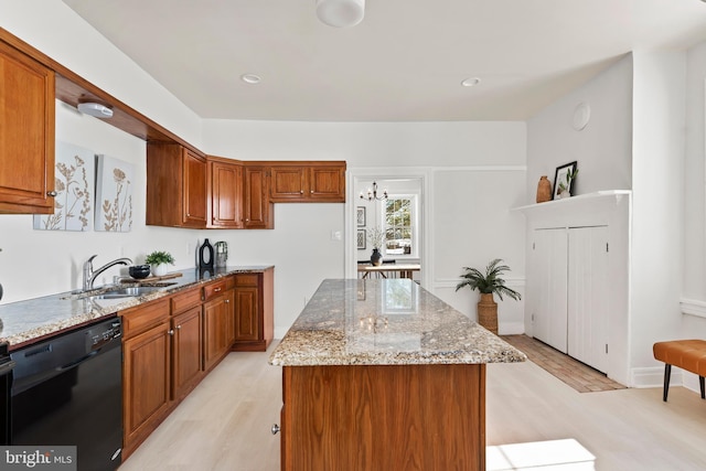 kitchen featuring a center island, dishwasher, sink, and light wood-type flooring