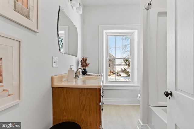 bathroom with vanity, hardwood / wood-style flooring, and shower / washtub combination