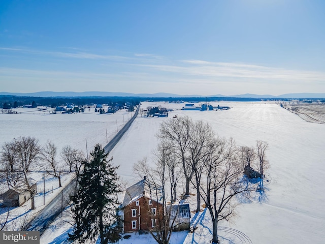 snowy aerial view with a mountain view and a rural view