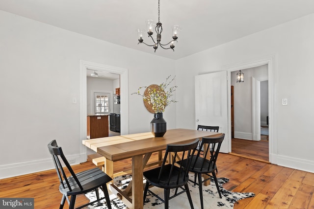 dining room with wood-type flooring and an inviting chandelier