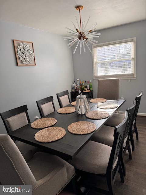 dining room with hardwood / wood-style floors and an inviting chandelier