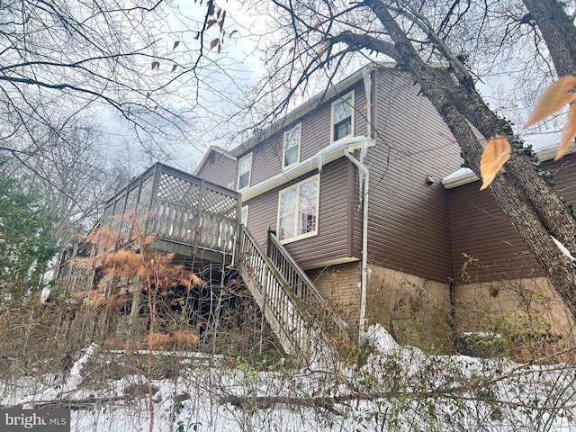 view of snow covered exterior with a deck