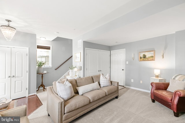 carpeted living room featuring a notable chandelier