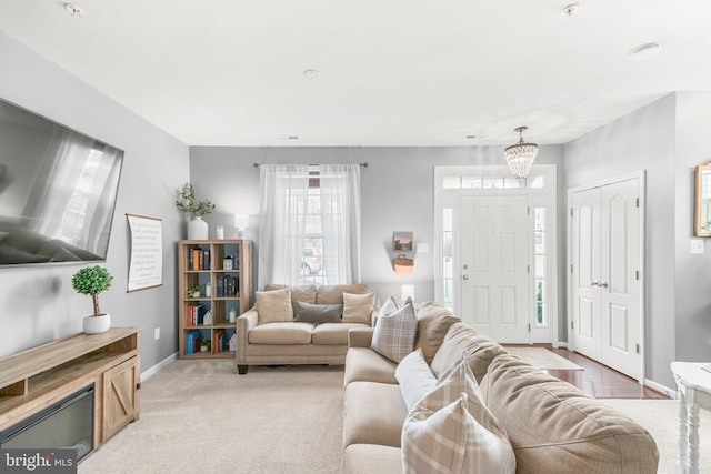 living room with light colored carpet and a chandelier