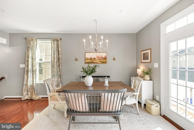 dining space with wood-type flooring and a notable chandelier