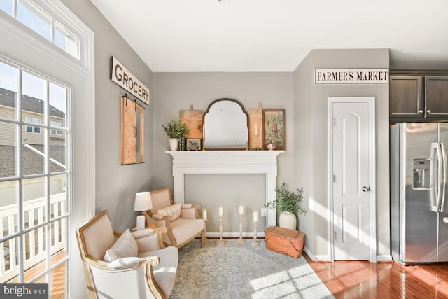 sitting room with a fireplace and light hardwood / wood-style floors