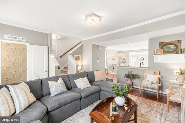 living room with crown molding, wood-type flooring, and a notable chandelier