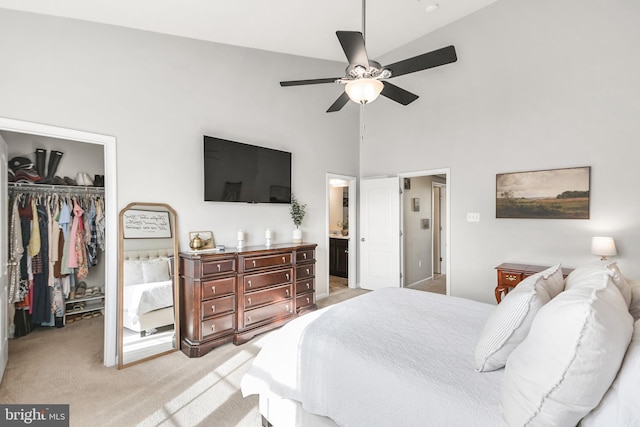 carpeted bedroom featuring ensuite bath, ceiling fan, a towering ceiling, a spacious closet, and a closet