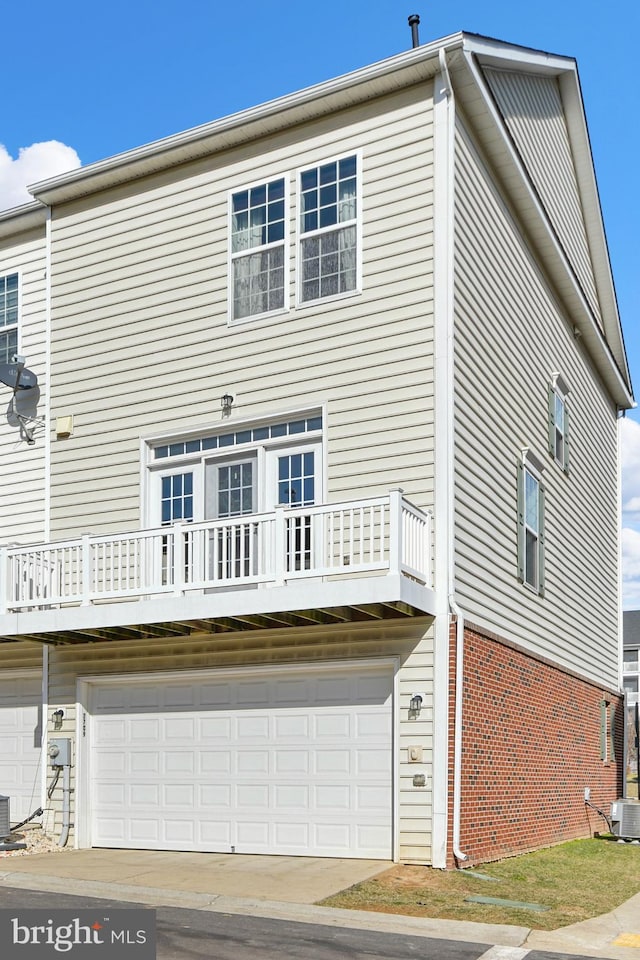 back of property featuring a garage and central air condition unit