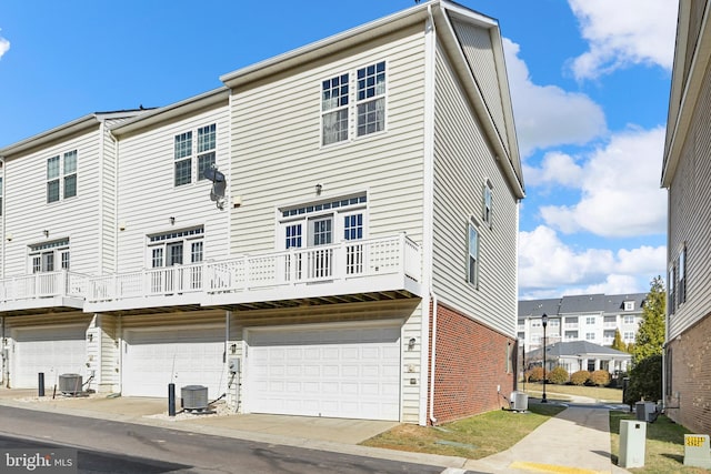 back of house featuring a garage and central AC unit