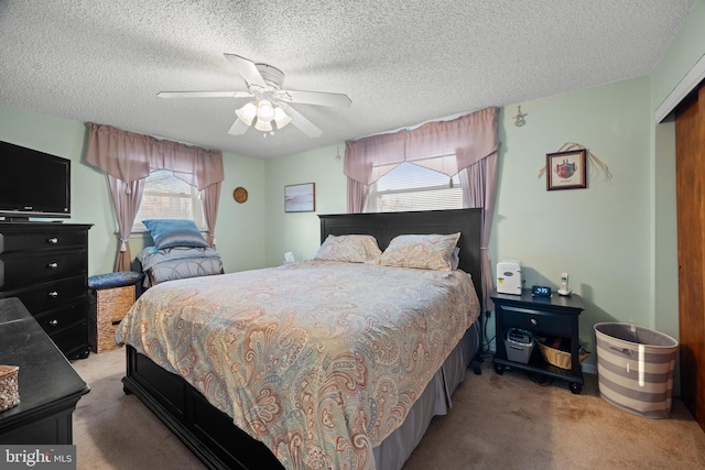 carpeted bedroom featuring multiple windows, a textured ceiling, ceiling fan, and a closet