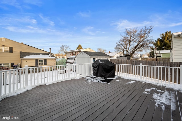 wooden terrace featuring a grill and an outbuilding