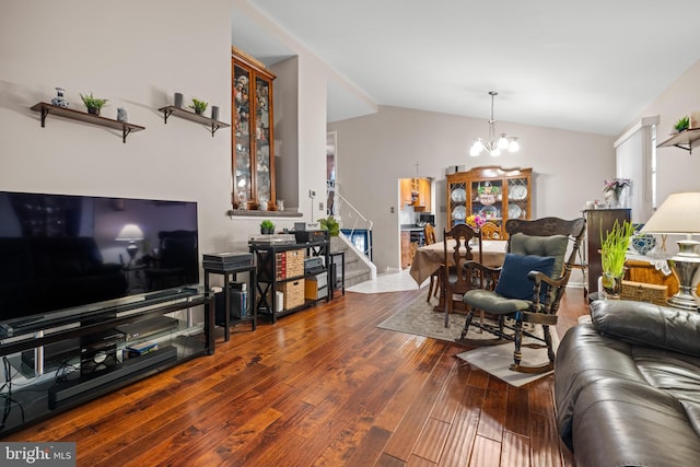 living room with lofted ceiling, hardwood / wood-style floors, and a notable chandelier