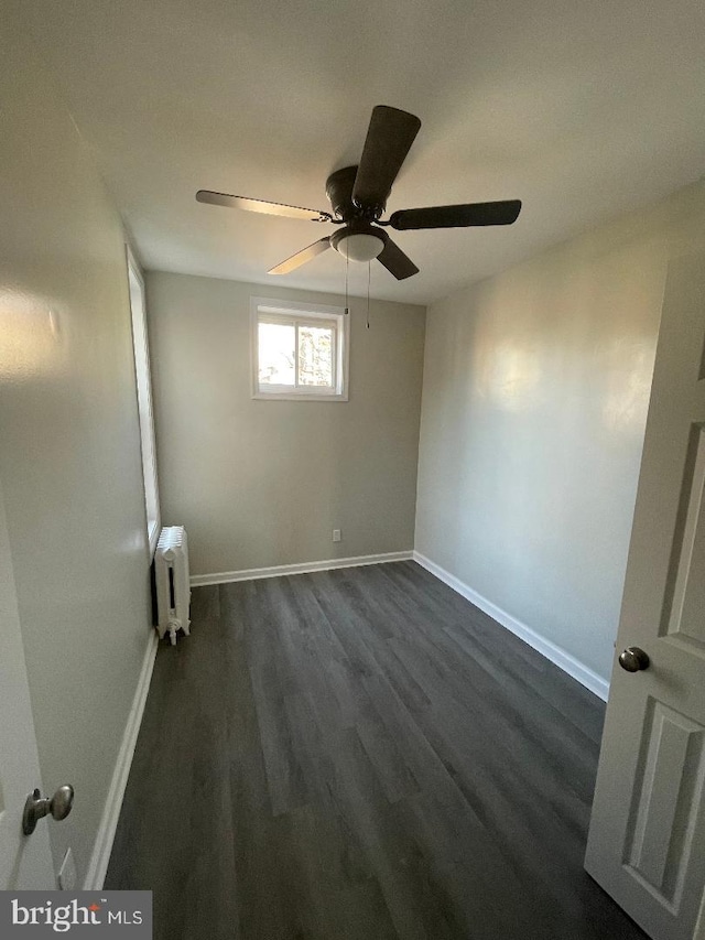 unfurnished room featuring ceiling fan, radiator heating unit, and dark hardwood / wood-style flooring