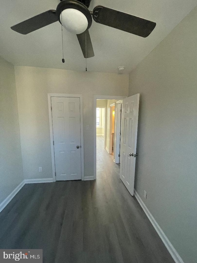 unfurnished bedroom featuring dark wood-type flooring and ceiling fan