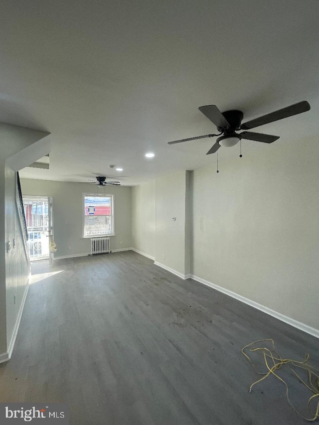 unfurnished room with radiator, wood-type flooring, and ceiling fan