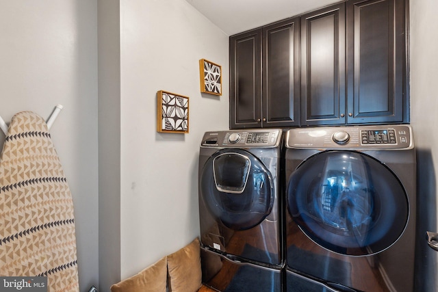 clothes washing area with washing machine and dryer and cabinets