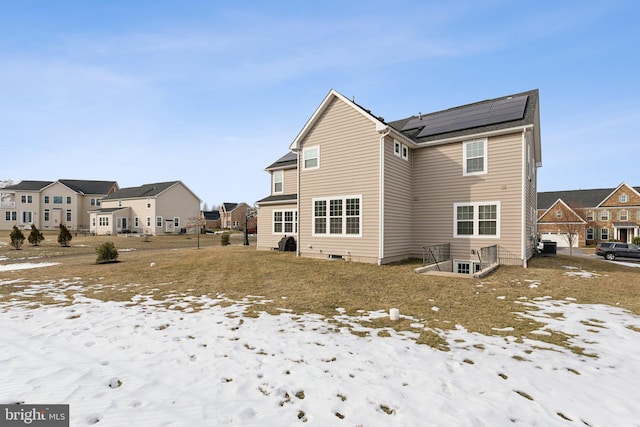 snow covered property featuring solar panels