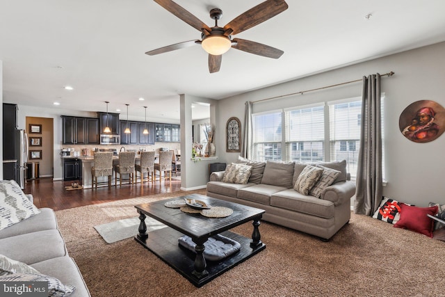 living room with dark wood-type flooring and ceiling fan