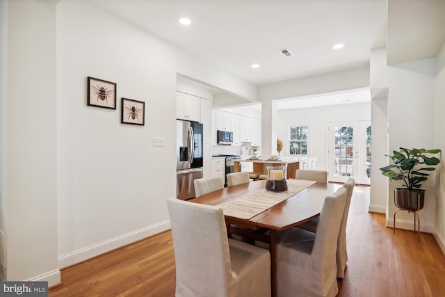 dining room featuring french doors and light hardwood / wood-style flooring