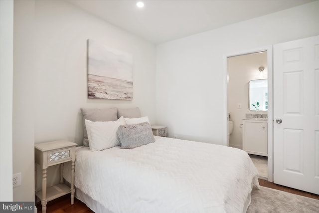 bedroom featuring ensuite bath, wood-type flooring, and sink