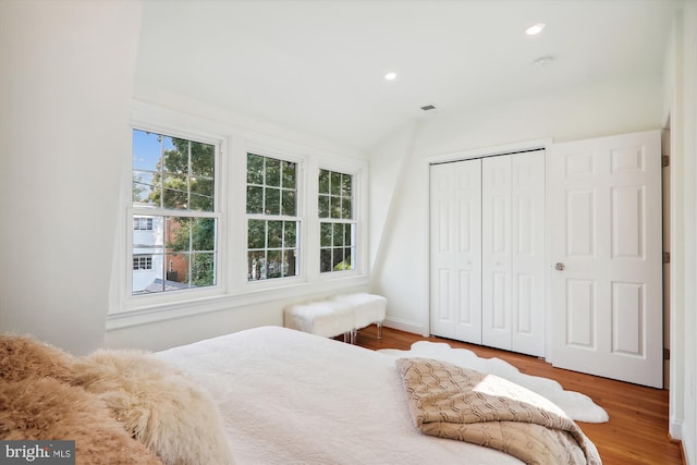 bedroom with wood-type flooring and a closet