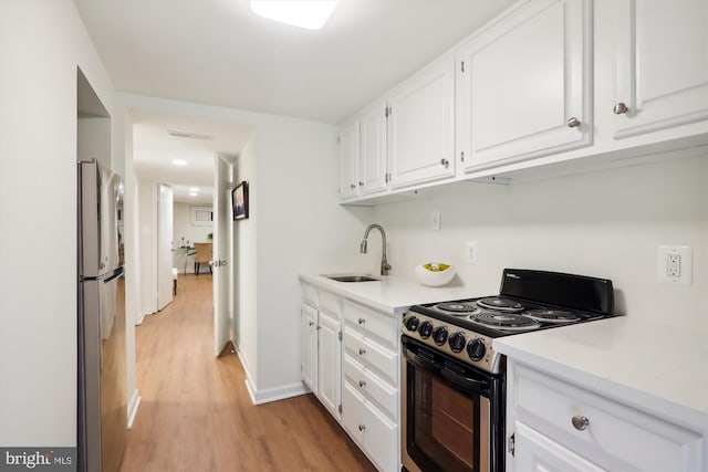 kitchen with white cabinetry, stainless steel appliances, light hardwood / wood-style floors, and sink