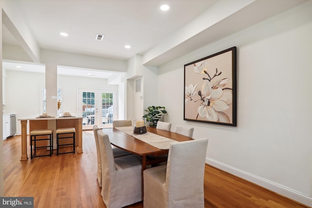 dining space with french doors and light hardwood / wood-style flooring