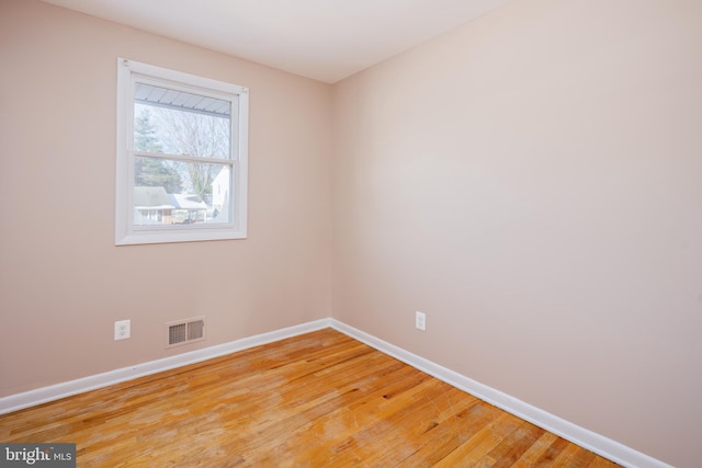 spare room with visible vents, light wood-style flooring, and baseboards