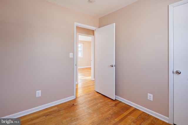 unfurnished bedroom featuring light wood-style floors and baseboards