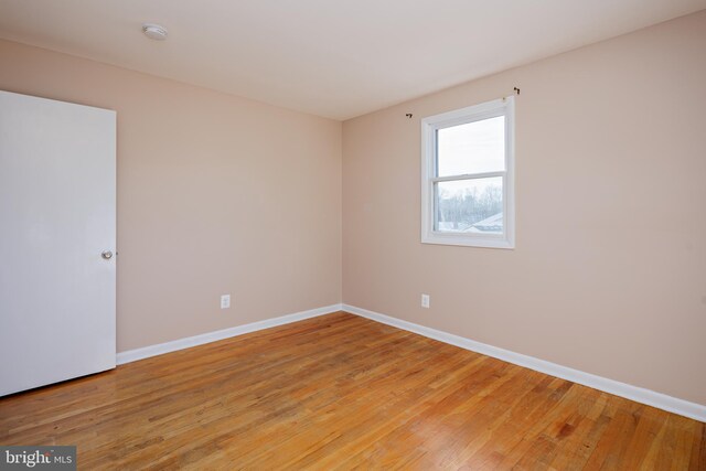 empty room featuring light wood finished floors and baseboards