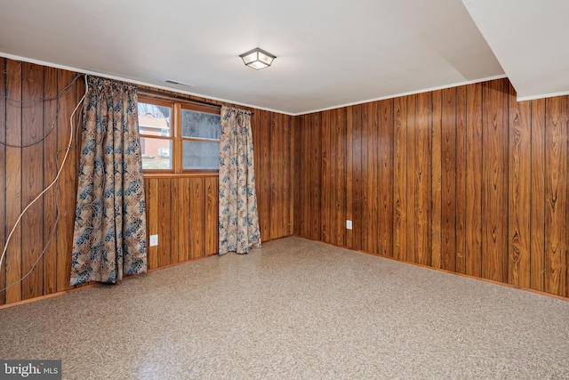 empty room with visible vents and wood walls