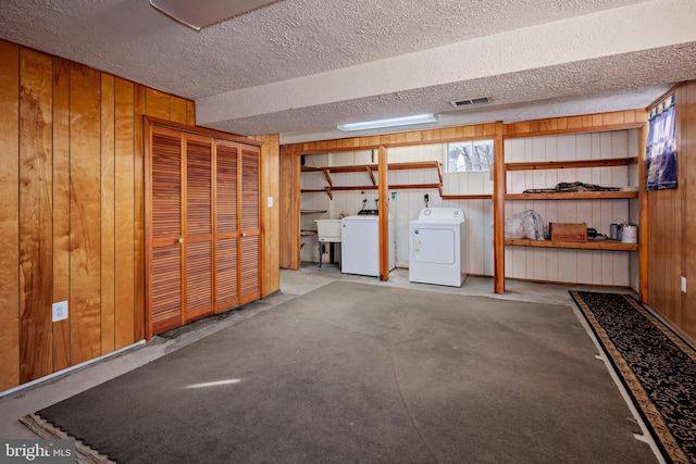 below grade area featuring visible vents, wood walls, and a textured ceiling