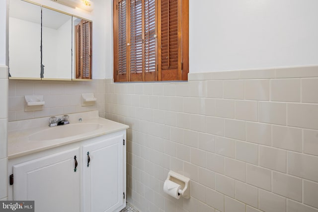 bathroom with vanity, tile walls, and wainscoting