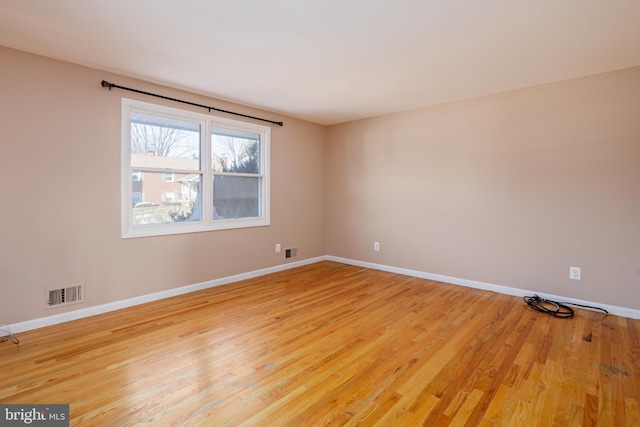 unfurnished room featuring baseboards, visible vents, and light wood finished floors